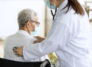 Una metgessa atenent a un pacient d'una residència de gent gran