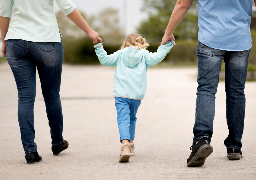 Una mare i un pare gaudint del permís parental amb al seva filla